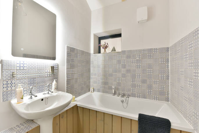 Bathroom with a bath tub, flushing toilet and sink