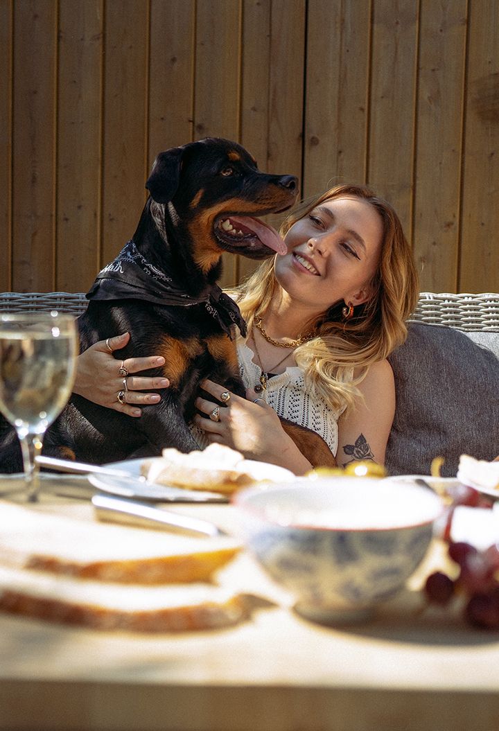 Person enjoying an outdoor lunch with their dog 