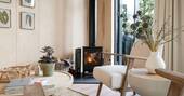 Living area with a wood burner, armchairs and a coffee table