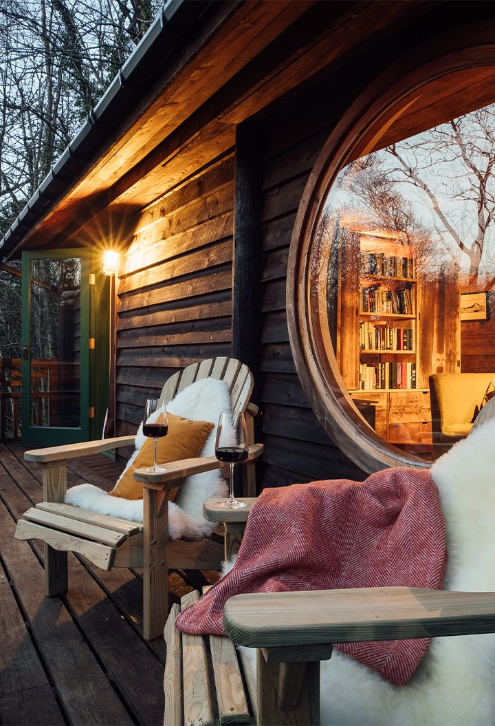 Cosy outdoor seating with fur, blankets, and glasses of red wine 